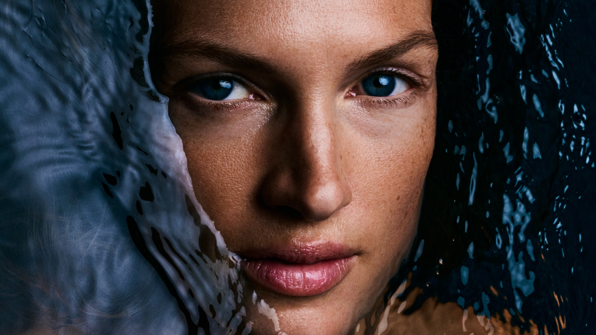 Close up of a woman's face surrounded by water