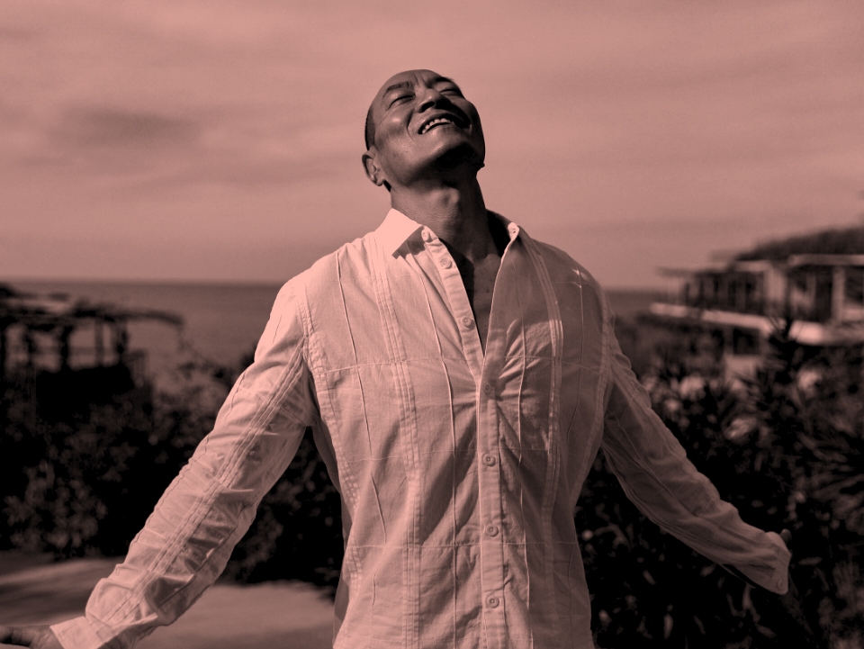 Man wearing a white shirt with his eyes closed facing up to the sun