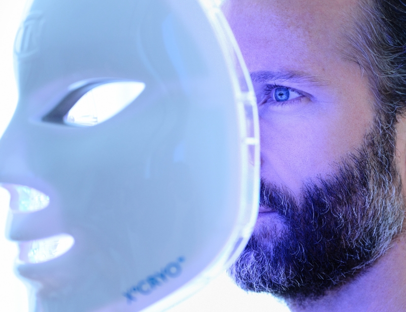 man applying LED mask to his face