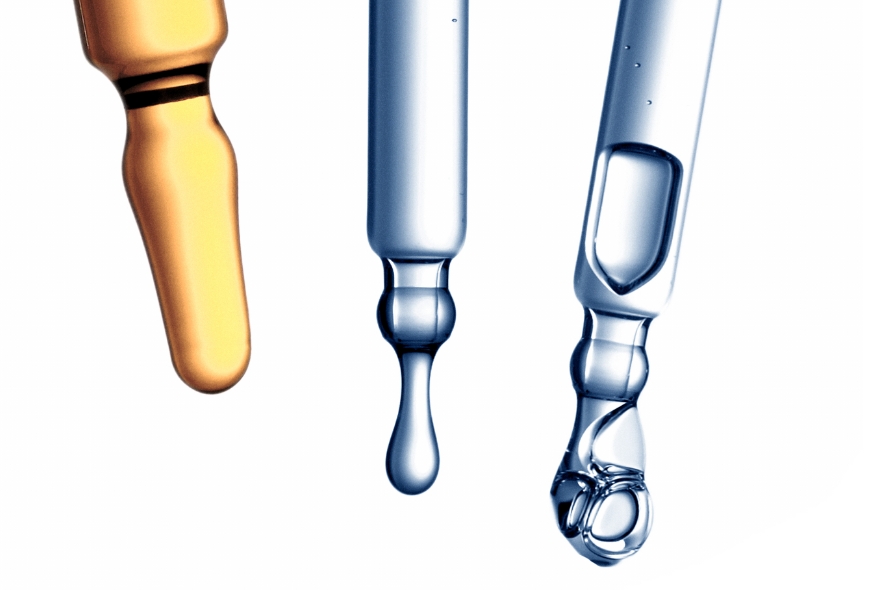 three pipettes containing beauty serums